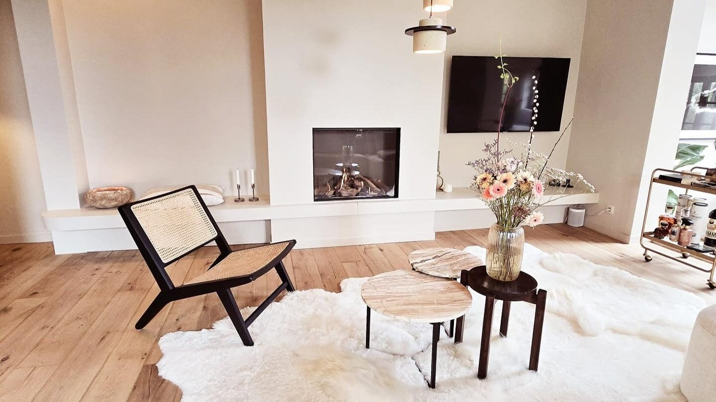 Off white schapenvacht tapijt in een lichte loft met design lounge chair