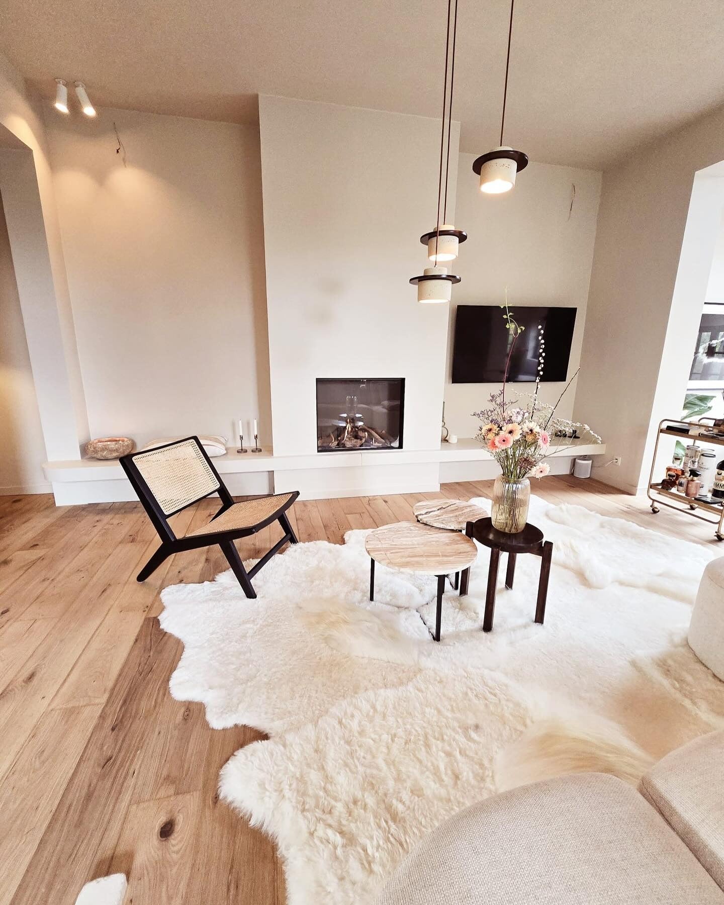 Off white schapenvacht tapijt in een lichte loft met design lounge chair